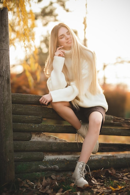 Ritratto di una bionda affascinante con un sorriso stupendo Ragazza in un maglione bianco