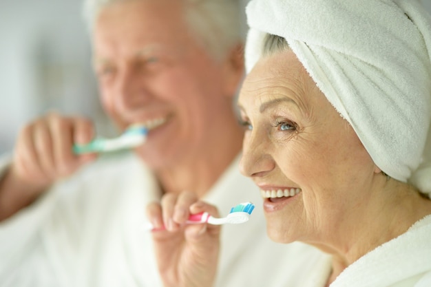 Ritratto di una coppia anziana con spazzolini in bagno