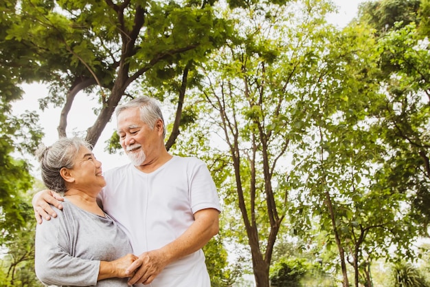 Ritratto di una coppia asiatica anziana in pensione che mostra amore con calore e gioia in giardino