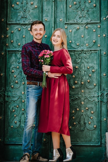 Ritratto di una coppia di amanti felici con un mazzo di fiori sulla strada sorridente, godetevi i suoi fine settimana Stile di vita alla moda e soleggiato estivo