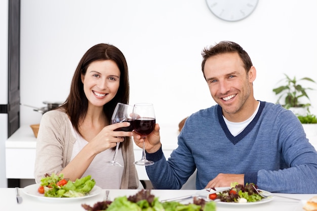 Ritratto di una coppia felice che beve vino rosso a pranzo