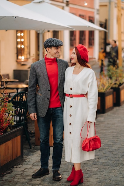 Ritratto di una coppia felice che cammina per strada in una città autunnale Elegante coppia in stile retrò in autunno in città