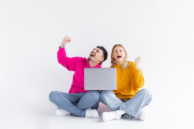 Ritratto di una coppia gioiosa eccitata che tiene il computer portatile