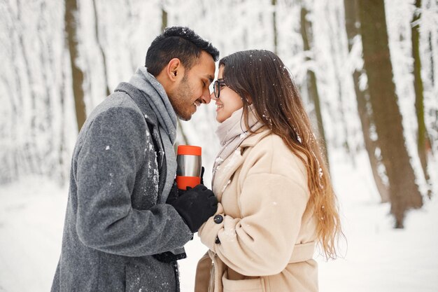 Ritratto di una coppia romantica che trascorre del tempo insieme nella foresta invernale