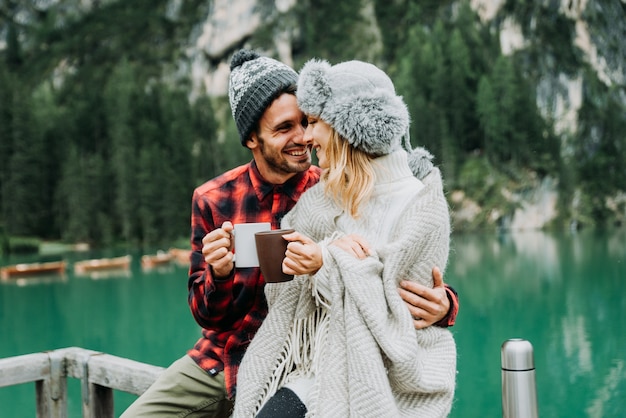 Ritratto di una coppia romantica di adulti che visitano un lago alpino a Braies Italia in inverno