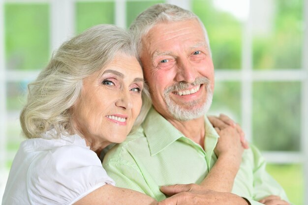 Ritratto di una coppia senior felice che si abbraccia a casa