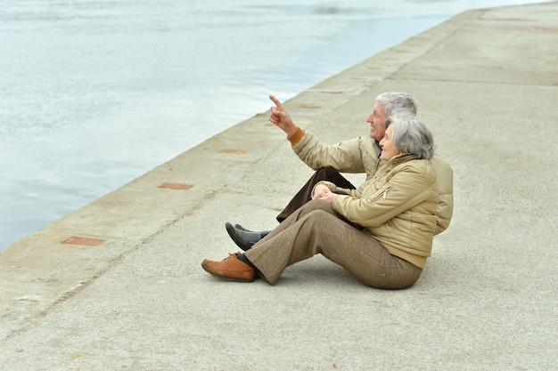 Ritratto di una coppia senior felice vicino al lago