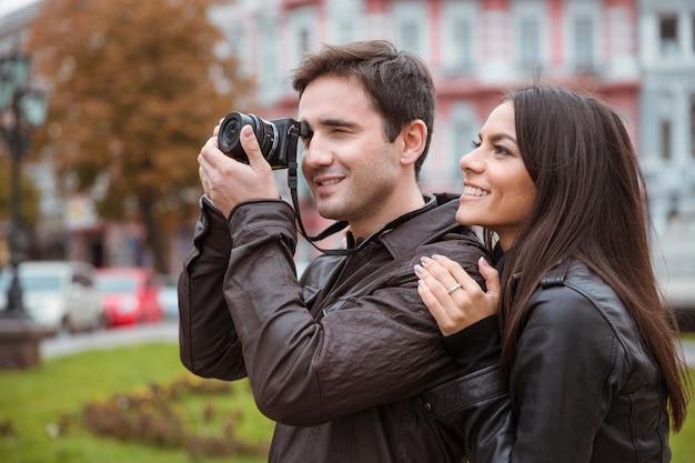 Ritratto di una coppia sorridente in viaggio e fare foto sulla parte anteriore nella vecchia città europea