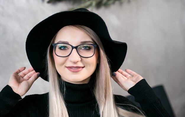 Ritratto di una donna abbastanza giovane che tiene un cappello con le mani e guarda la telecamera