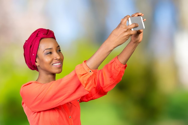 Ritratto di una donna afroamericana sorridente che fa foto selfie