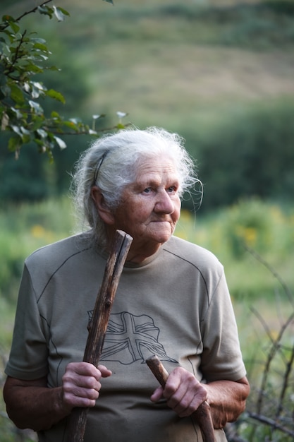 Ritratto di una donna anziana che cammina in un prato erboso