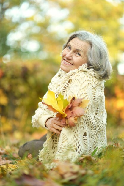 Ritratto di una donna anziana felice nel parco autunnale