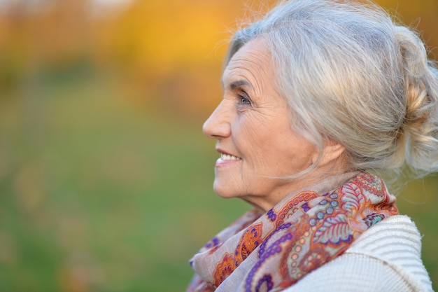 Ritratto di una donna anziana felice nel parco autunnale