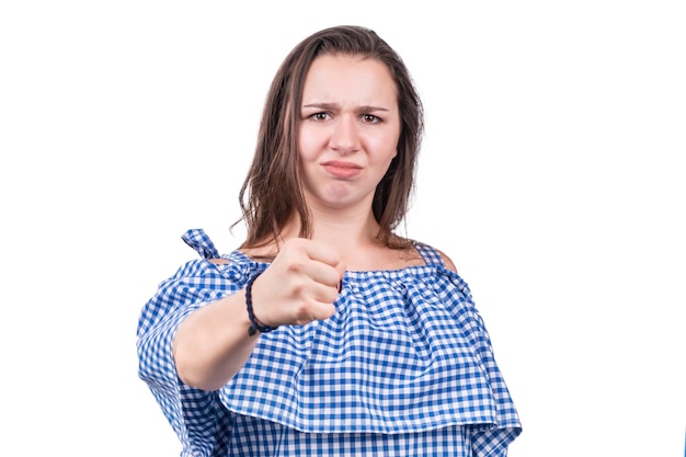 Ritratto di una donna arrabbiata che mostra un pugno alla telecamera, isolata su uno sfondo bianco