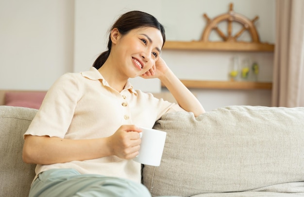 Ritratto di una donna asiatica felice che si rilassa a casa