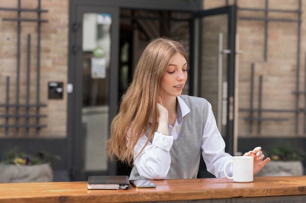 Ritratto di una donna attraente in città con copyspace caffè