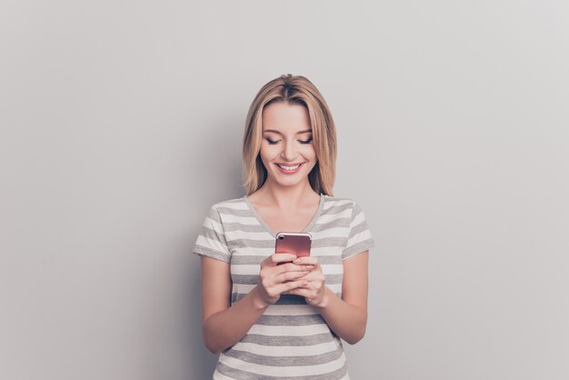 Ritratto di una donna bionda attraente utilizzando smartphone