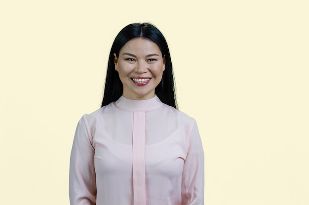 Ritratto di una donna castana asiatica allegra felice in camicetta convenzionale
