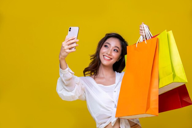 Ritratto di una donna che fotografa con un ombrello giallo