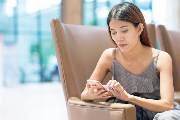 Ritratto di una donna che per mezzo di uno smartphone