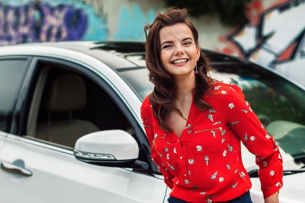 Ritratto di una donna contro un'auto bianca