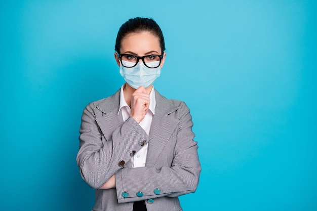 Ritratto di una donna d'affari attraente con contenuti intelligenti che pensa di toccare il mento indossando una maschera isolata su uno sfondo di colore blu brillante