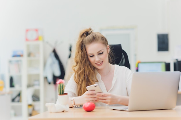 Ritratto di una donna d'affari seria utilizzando il computer portatile in ufficio Bella donna hipster prendendo appunti in ufficio moderno