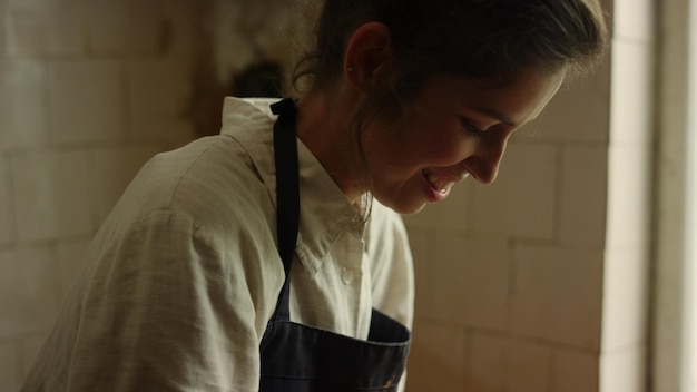 Ritratto di una donna felice che scolpisce in un laboratorio Closeup donna gioiosa che fa artigianato in studio Ragazza eccitata che prova gioia nel fare prodotti in ceramica