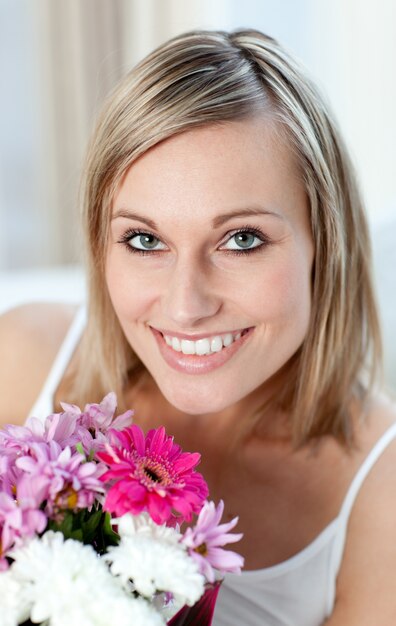 Ritratto di una donna felice che tiene un mazzo di fiori