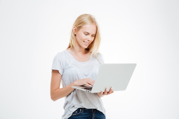 Ritratto di una donna felice utilizzando il computer portatile isolato su uno sfondo bianco