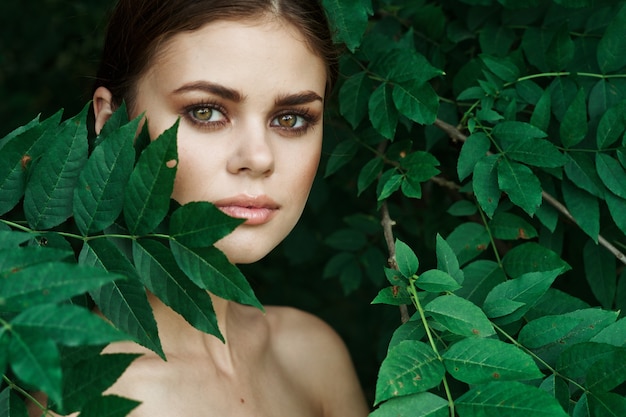 Ritratto di una donna foglie verdi pelle pulita modello estivo natura