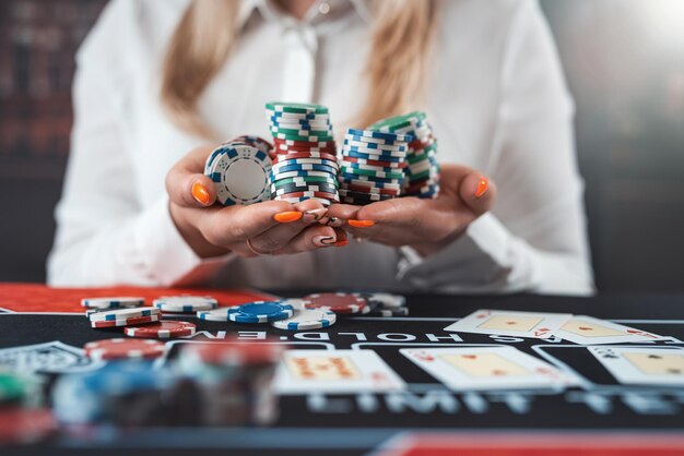 Ritratto di una donna fortunata che gioca a poker al tavolo del casinò Carte e fiches Stile di vita notturno