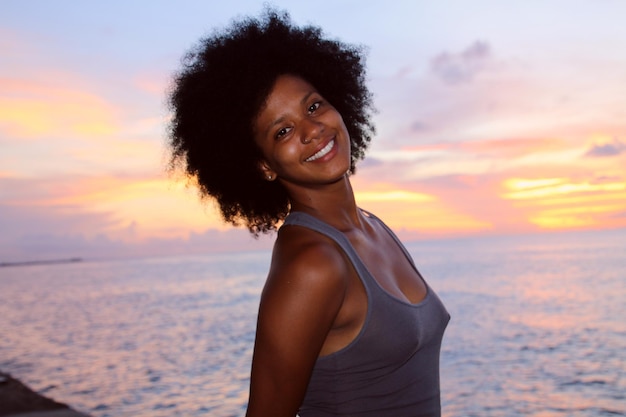 Ritratto di una donna in piedi sulla spiaggia al tramonto