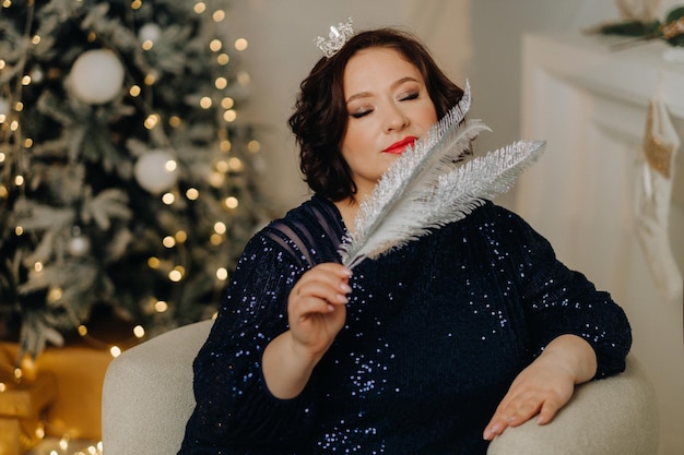 Ritratto di una donna in un abito blu lucido in un interno di Capodanno Concetto Buon Natale e Felice Anno Nuovo