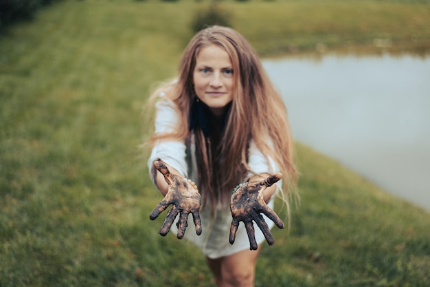 Ritratto di una donna incantatrice con le mani sporche e fangose