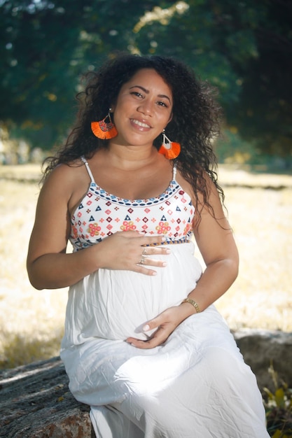 Ritratto di una donna incinta con i capelli afro in città