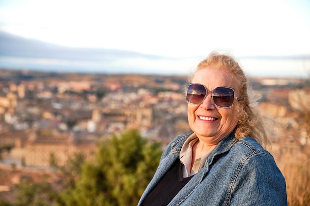 Ritratto di una donna matura sorridente di 75 anni con i capelli biondi che guarda l'obbiettivo