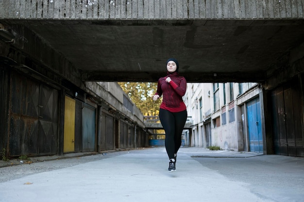 Ritratto di una donna musulmana seria mentre corre per le strade