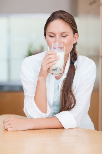 Ritratto di una donna sorridente che beve latte