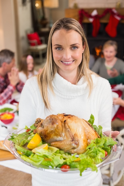 Ritratto di una donna sorridente che mostra il tacchino arrosto