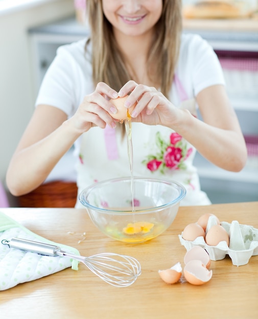 Ritratto di una donna sorridente che prepara una torta in cucina