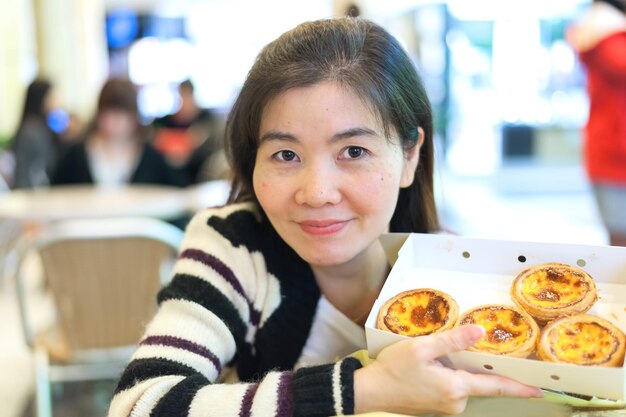 Ritratto di una donna sorridente che tiene il cibo in una scatola