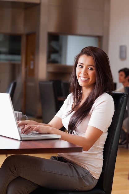 Ritratto di una donna sorridente utilizzando un notebook