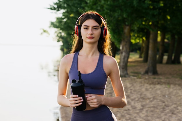 Ritratto di una donna sportiva mentre fa jogging sulla spiaggia Allenamento al di fuori di uno stile di vita attivo