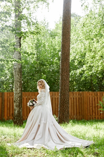 Ritratto di una donna sposa in un abito da sposa con un mazzo di fiori nelle sue mani