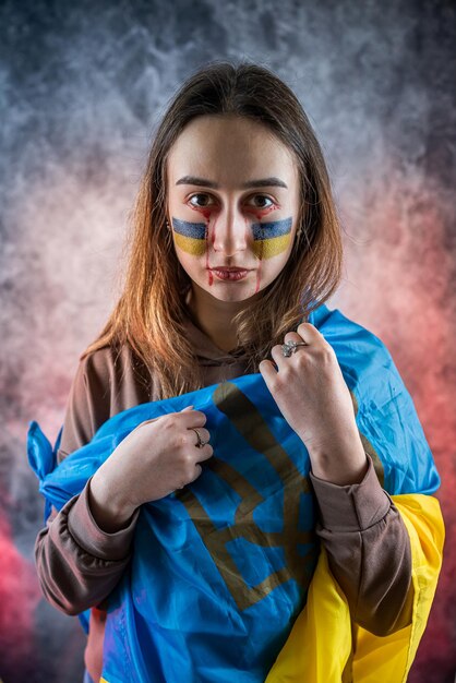 Ritratto di una donna ucraina con una bandiera sulla guancia tristezza desiderosa di speranza di pace