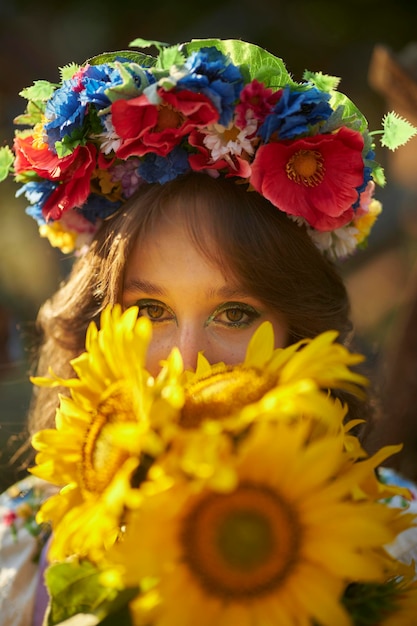 ritratto di una donna ucraina in abito vyshyvanka con un mazzo di girasoli, ricci anticarro