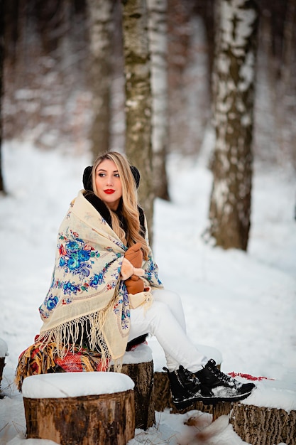 Ritratto di una donna ucraina in un bosco invernale con una sciarpa Trucco professionale Abbigliamento caldo