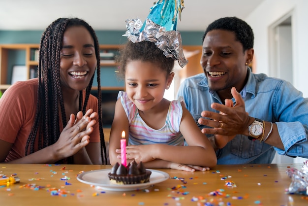 Ritratto di una famiglia che festeggia il compleanno in linea su una videochiamata mentre si resta a casa.