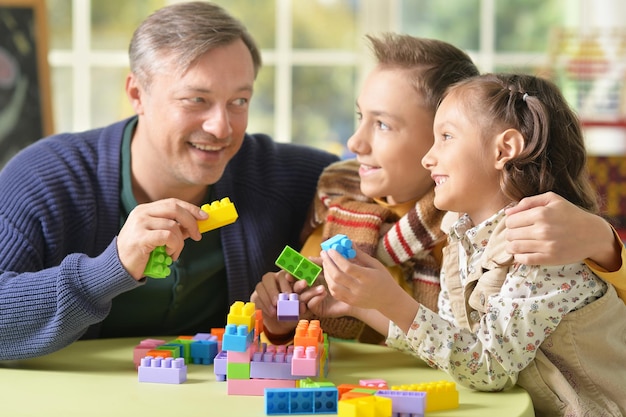 Ritratto di una famiglia che gioca a costruire, padre con bambini